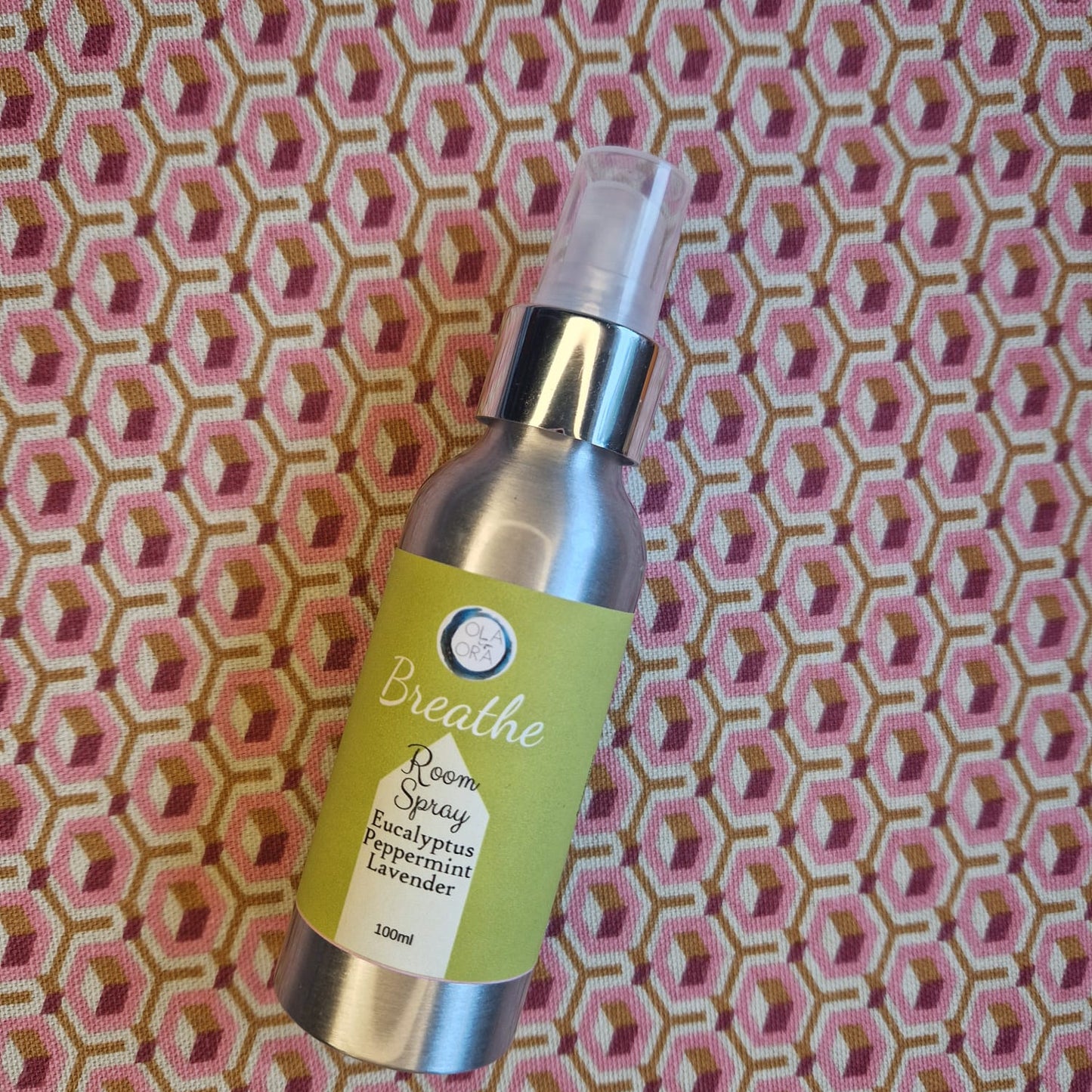 Aromatherapy Room Spray Bottle of 'Breathe' room spray on a patterned fabric background