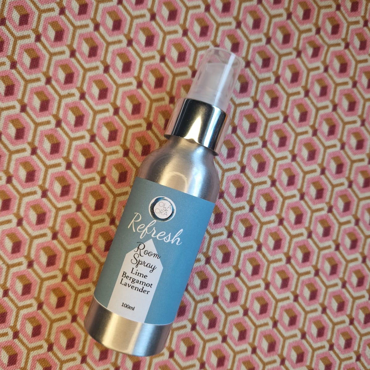 Bottle of 'Refresh' room spray on a patterned background