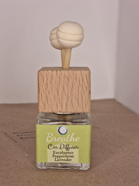 Car diffuser with wooden top and clear container on a brown surface