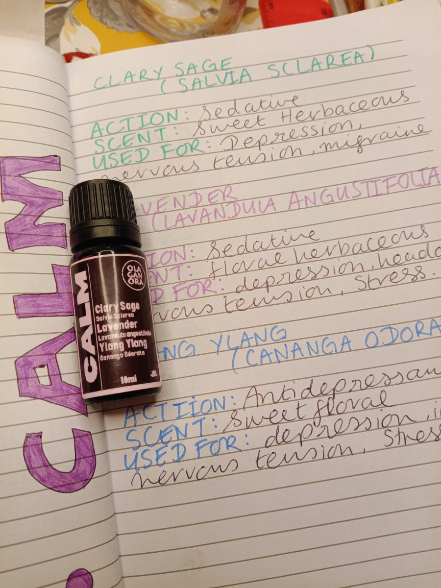 Calm aromatherapy diffuser oil blend with a notebook with writing about the oils in the blend