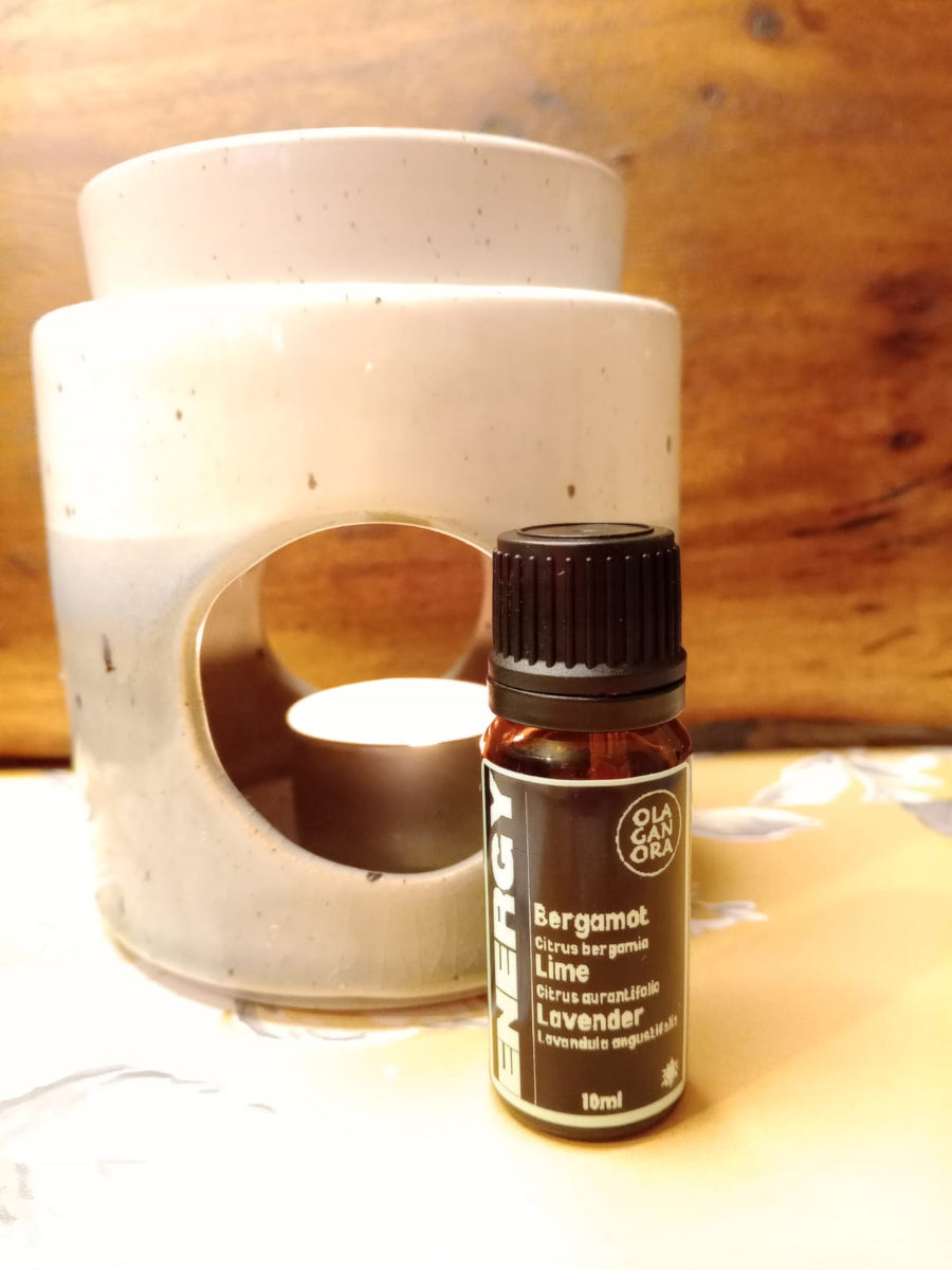 Energy aromatherapy diffuser blend in an amber bottle in front of a ceramic diffuser
