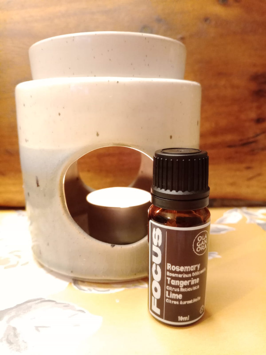 Focus Aromatherapy diffuser blend with Rosemary Tangerine And Lime Essential OIls in front of a ceramic oil burner
