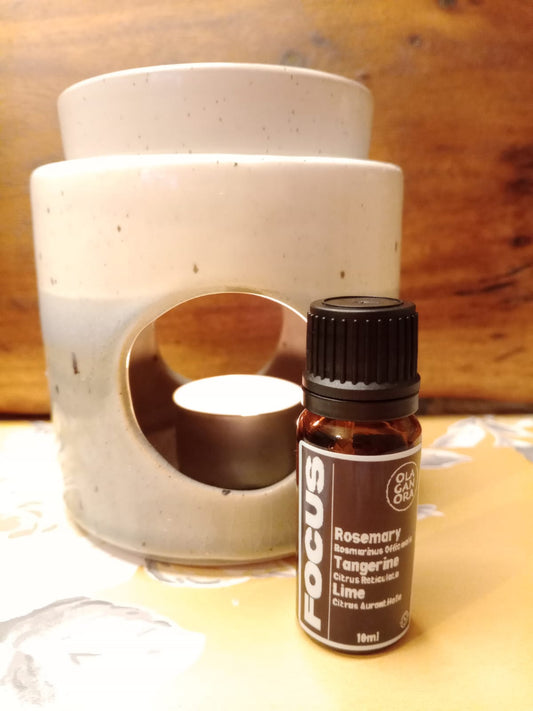 Focus Aromatherapy diffuser blend with Rosemary Tangerine And Lime Essential OIls in front of a ceramic oil burner